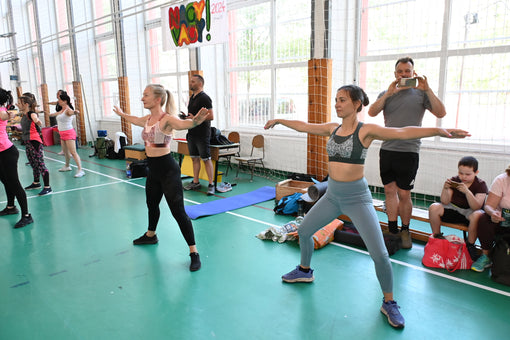 Customer picture: two women in aerobics class wearing the pink and green Tigers Eye bras.