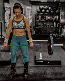 Hungarian military woman weight lifting in the gym wearing the green Tigers Eye bra.