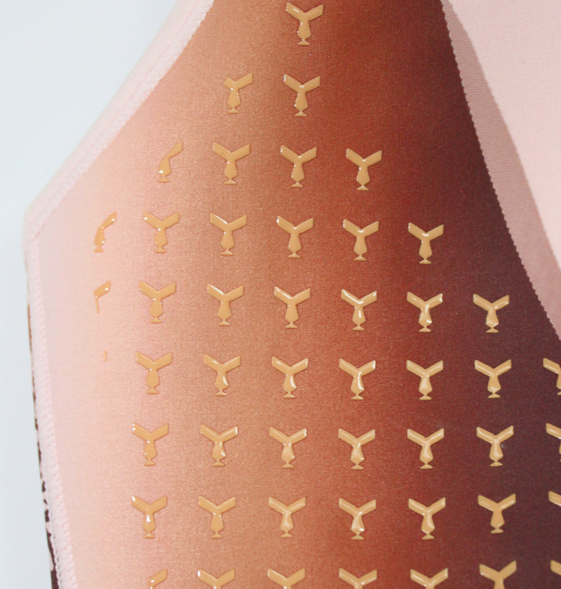Close-up of the pink Tigers Eye sports bra, highlighting the light orange silicone grips, shaped like the logo mark, on the inside of the molded cups for additional support and reduced breast movement.