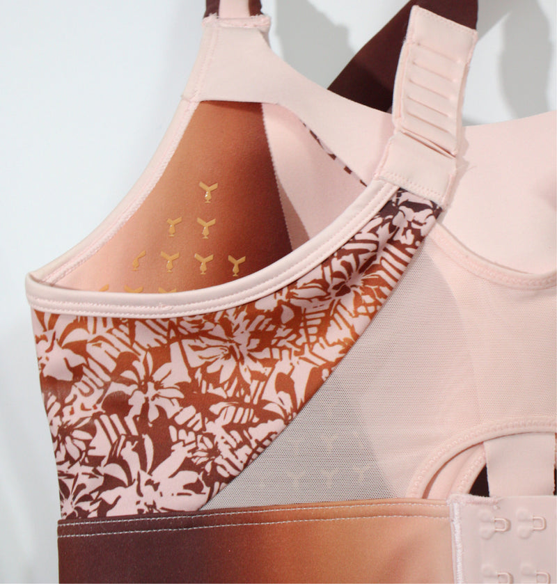 Close-up of the pink Tigers Eye sports bra, showing the enclosed closures at the back on the adjustable straps and underband; designed to prevent hot spots, chafing, and digging, and made to be worn under equipment.