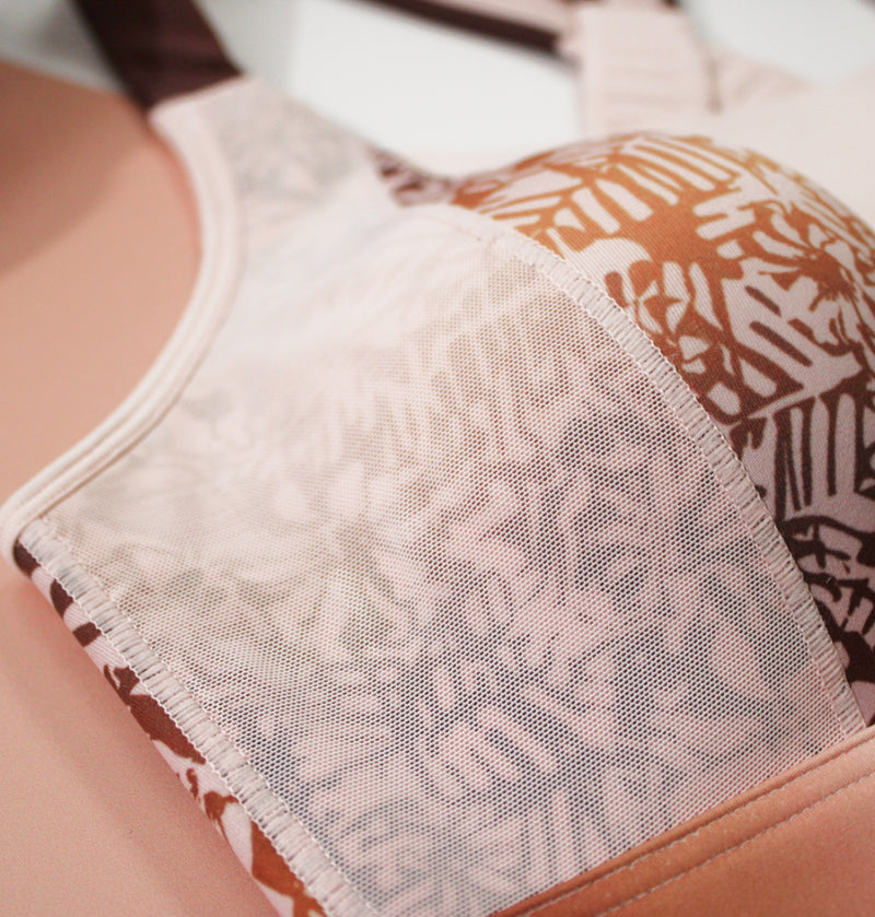 Close-up of the Pink Tigers Eye sports bra, highlighting the molded cups covered in breathable mesh for support and airflow.