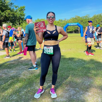 Active Duty military woman wearing the black Tigers Eye bra, posing with her race number.